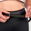 Close up of woman wearing Ultimate Direction Women's Hydro Tight, side view, showing woman adjusting waist belt