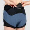 Close up of Ultimate Direction Women's Hydro Short, showing woman placing phone in pocket