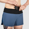 Close up of Ultimate Direction Women's Velum Short, showing woman placing phone into pocket