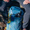 Ultimate Direction Fastpack 30 with trekking poles stored in exterior pocket