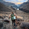 Woman carrying Ultimate Direction Fastpack 40 in the mountains