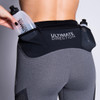 Woman wearing Ultimate Direction Women's Hydro 3/4 Tight, putting water bottle into side pocket