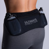 Woman wearing Ultimate Direction Women's Hydro 3/4 Tight, rear view, with water bottles