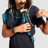 Close up of man wearing Ultimate Direction Race Vest, cinching cord for trekking poles