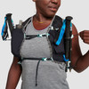 Close up of woman wearing Ultimate Direction Race Vesta, pulling cinch cord for trekking poles