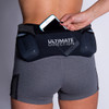 Woman wearing Ultimate Direction Women's Hydro Skin Short, putting phone into center pocket