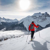 Man skiing in the mountains wearing an Ultimate Direction All Mountain pack