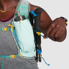 Close up of woman wearing Ultimate Direction Ultra Vesta, pulling cinch cord for trekking poles