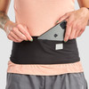 Woman wearing Ultimate Direction Utility Belt, pulling phone from pocket